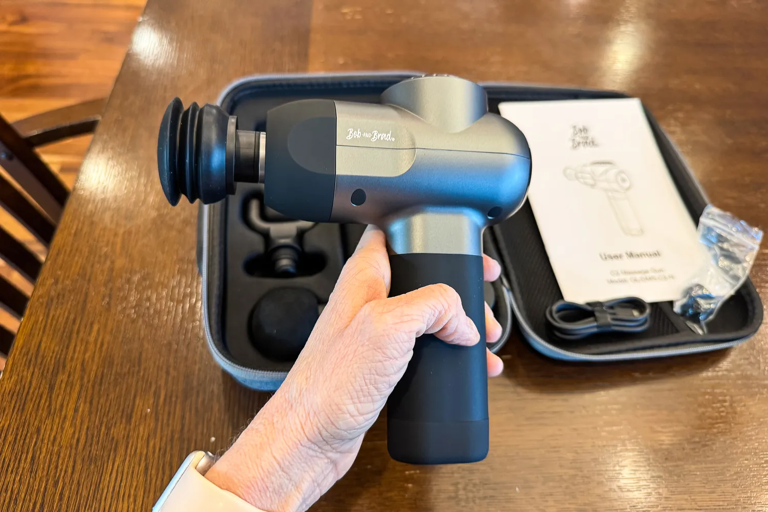 A person holds the Bob and Brad C2 Massage Gun in their hand