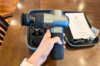 A person holds the Bob and Brad C2 Massage Gun in their hand