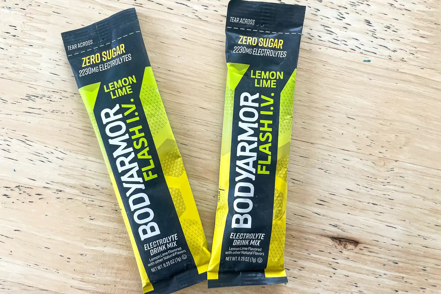 Two packets of BodyArmor Flash IV Lemon Lime electrolyte drink mix displayed on a wooden surface
