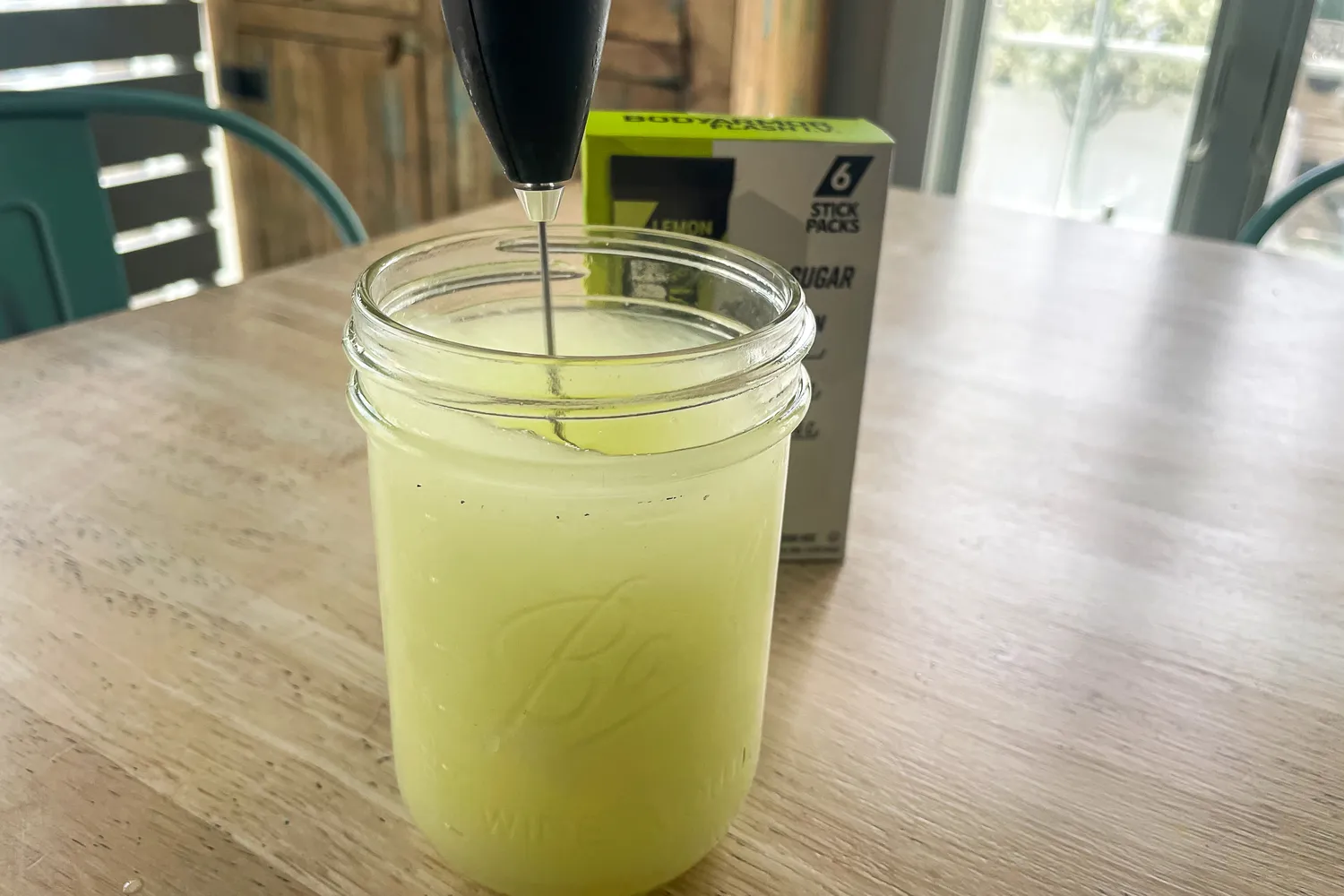 Mason jar with a whisk stirring liquid box with six packets in the background