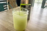 Mason jar with a whisk stirring liquid box with six packets in the background