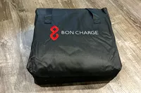 A folded Bon Charge Infrared Sauna Blanket on a wooden floor