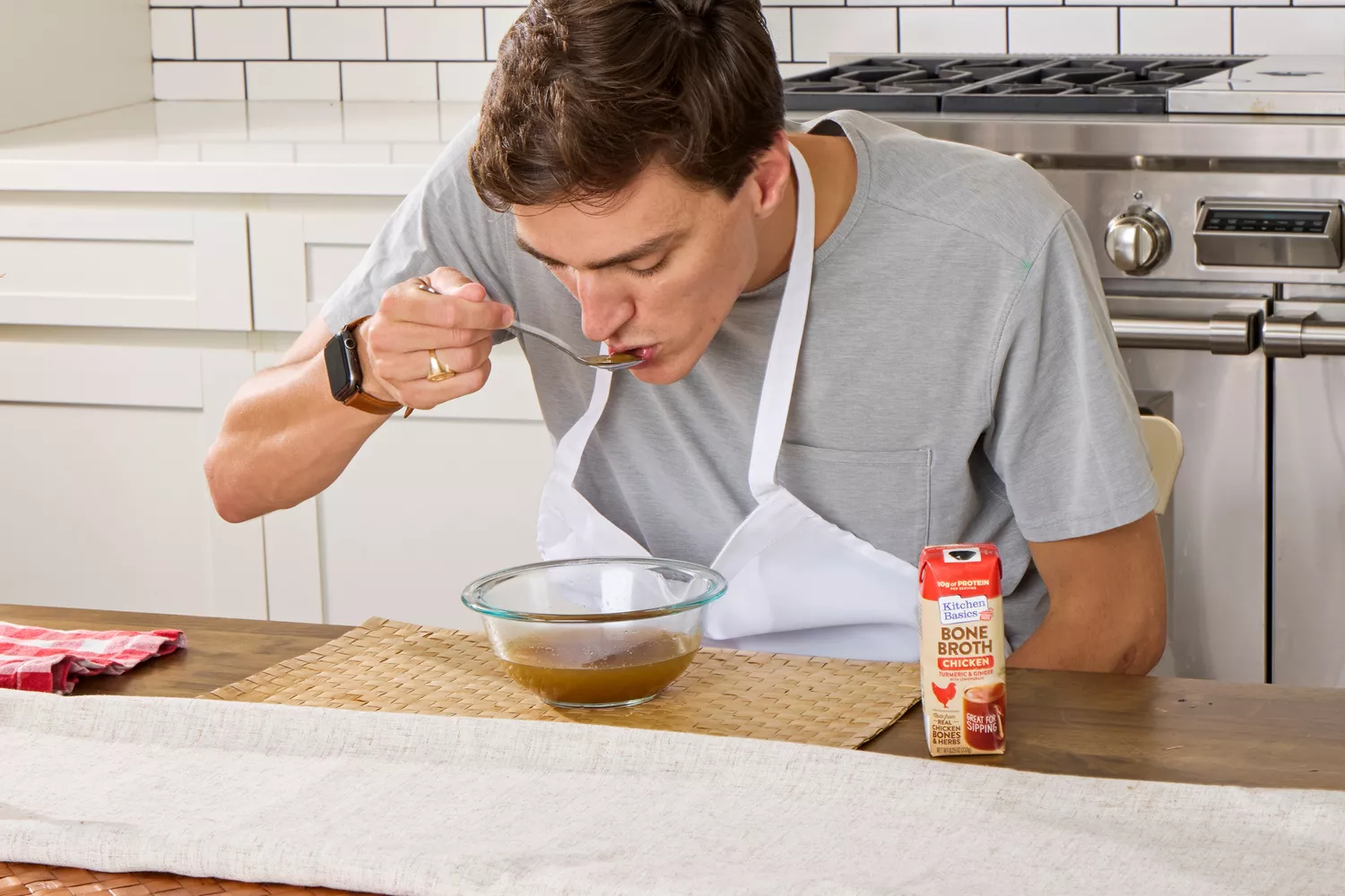 A person sips on Kitchen Basics Turmeric & Ginger With Lemongrass Chicken Bone Broth
