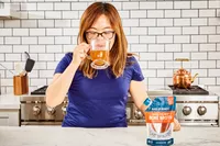 A person drink a glass of Bare Bones Grass-Fed Beef Organic Bone Broth