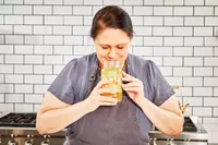 A person smells a jar of FOND Certified Organic Chicken Bone Broth