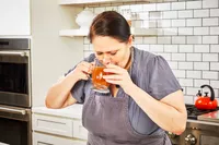 A person sips Kettle & Fire Bone Broth 