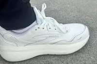 A close-up of a foot wearing the Brooks Men's Ghost Max L Sneaker on carpet