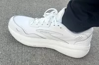 The Brooks Men's Ghost Max L Sneaker worn on carpet up close