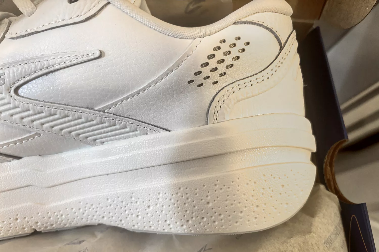 A close-up of a Brooks Men's Ghost Max L Sneaker heel in the box