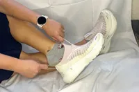 A person puts on the Brooks Women's Glycerin 22 SE Running Shoe