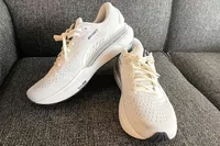 A pair of Brooks Men's Adrenaline GTS 24 Running Shoes on a couch