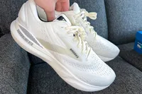 A person holds up a pair of Brooks Men's Adrenaline GTS 24 Running Shoes