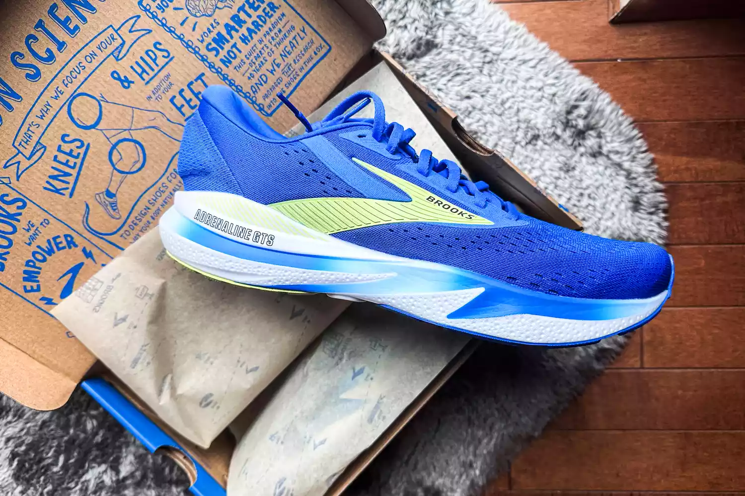 A side of the Brooks Men's Adrenaline GTS 24 Road Running Shoes in a shoebox