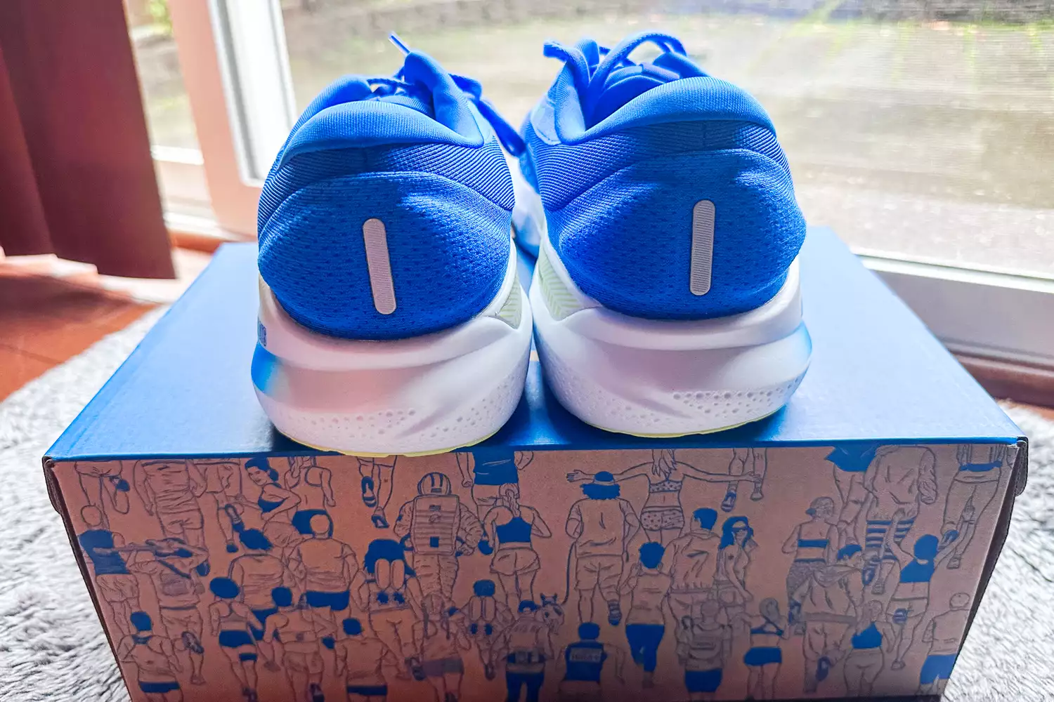 The Brooks Men's Adrenaline GTS 24 Road Running Shoes on top of a shoebox