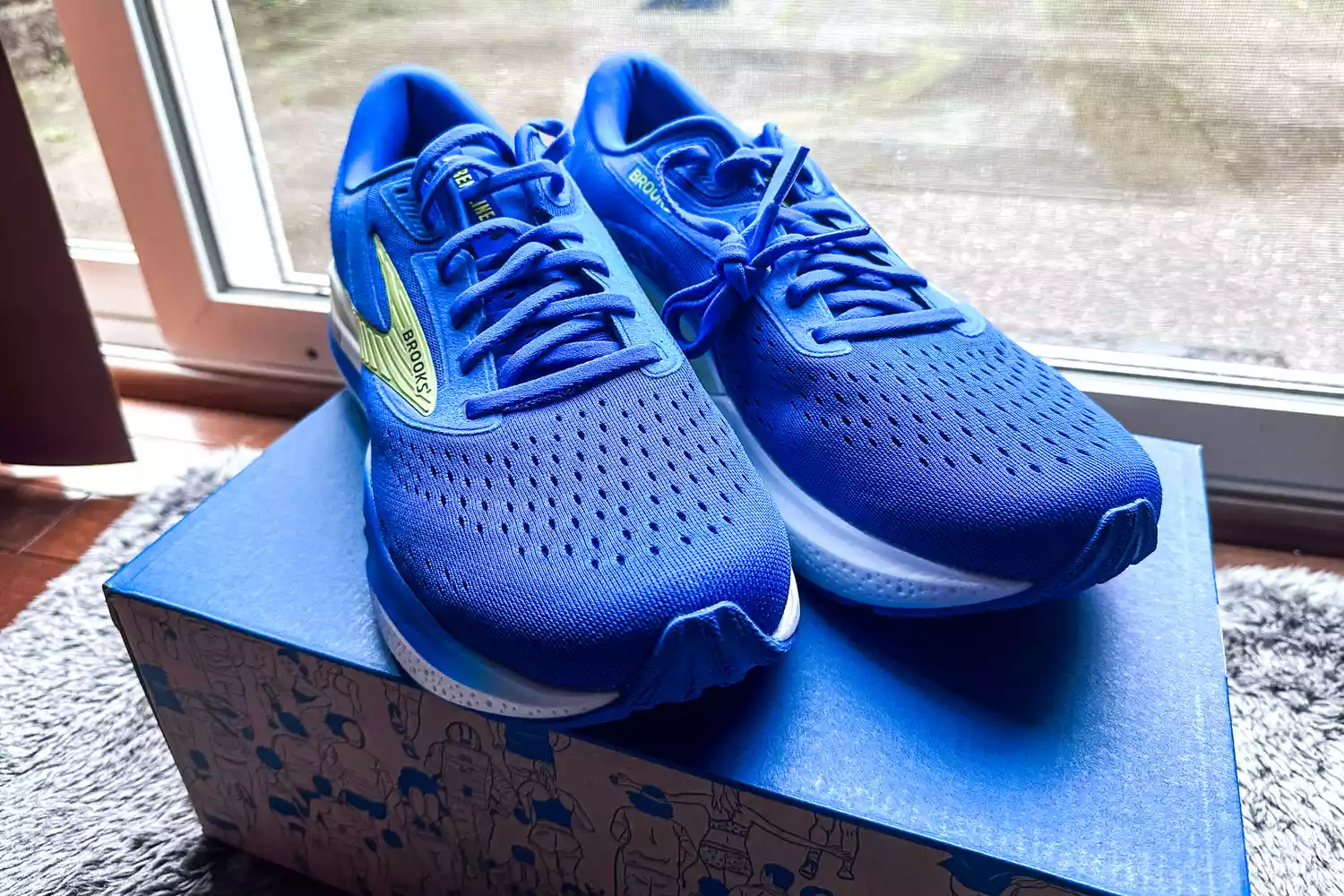 The Brooks Men's Adrenaline GTS 24 Road Running Shoes on top of a shoebox