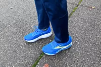 A person walks outside while wearing the Brooks Men's Adrenaline GTS 24 Road Running Shoes