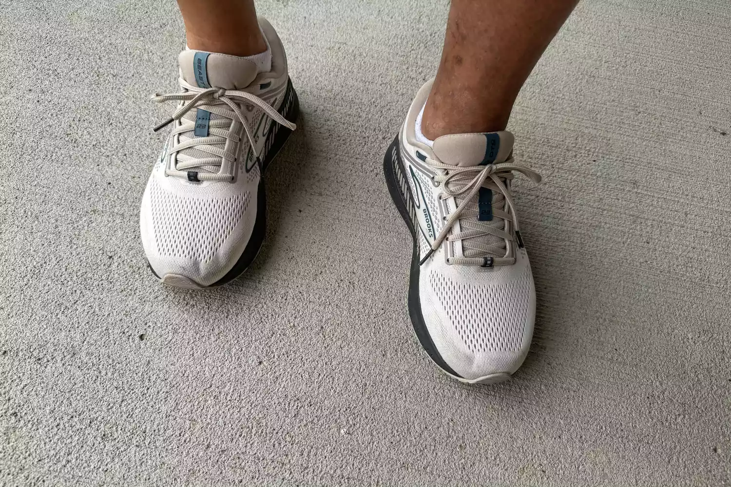 An overhead view of a person wearing the Brooks Men's Beast GTS 23 Running Shoe outside on concrete