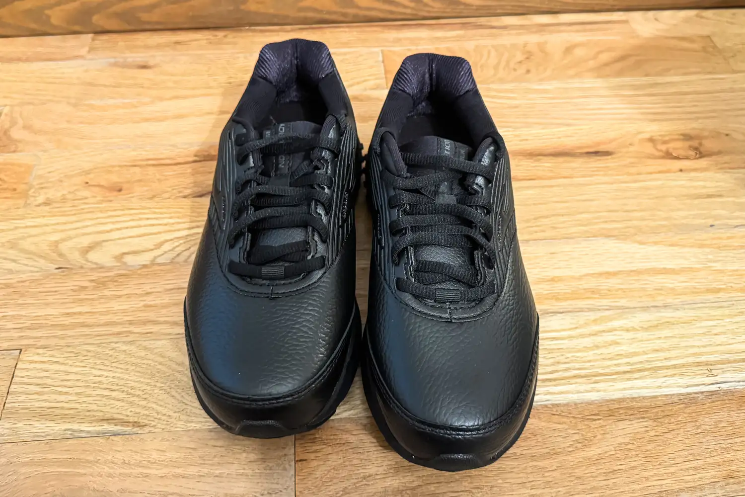 A pair of Women's Addiction Walker 2 Sneakers on a wooden floor