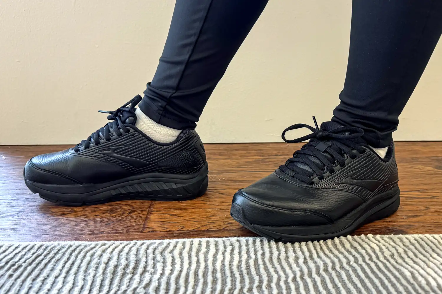 Women's Addiction Walker 2 Sneakers worn on a wooden floor with a striped rug nearby