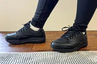 Women's Addiction Walker 2 Sneakers worn on a wooden floor with a striped rug nearby