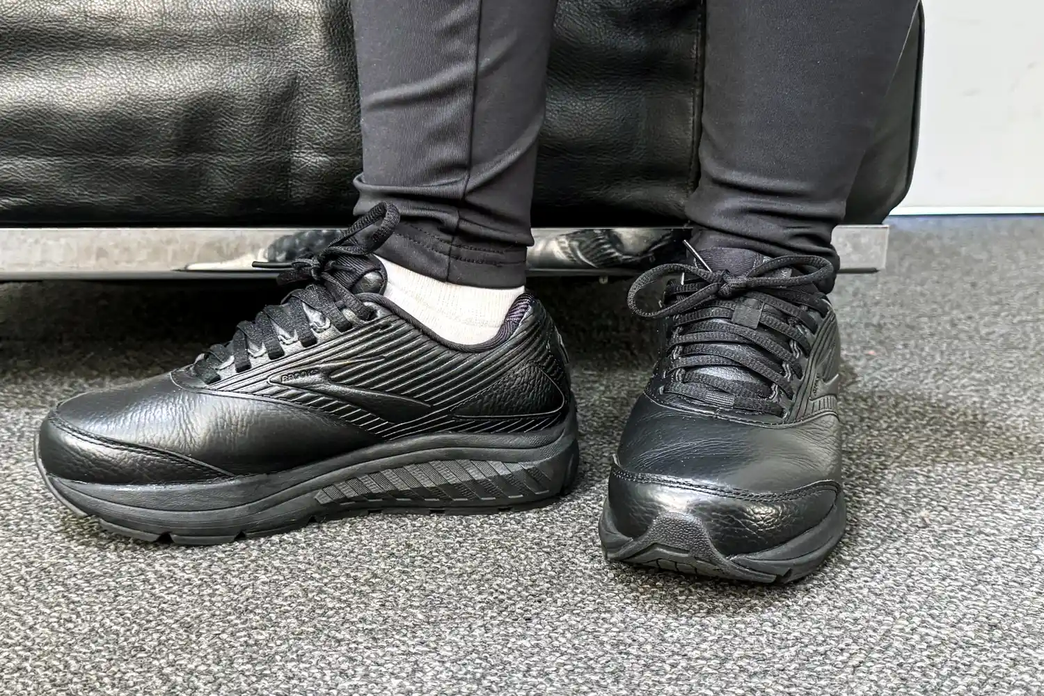 A person wearing Women's Addiction Walker 2 Sneakers and leggings near on a bench