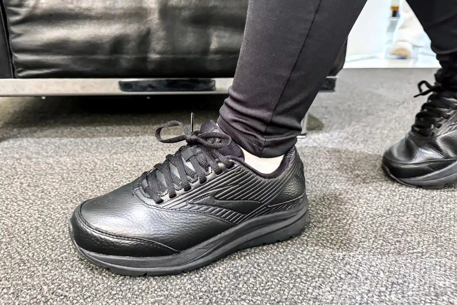 A person wearing the Women's Addiction Walker 2 Sneakers walks on carpeting