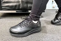 A person wearing the Women's Addiction Walker 2 Sneakers walks on carpeting