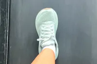 A person walks on a treadmill while wearing the Brooks Women's Adrenaline GTS 24 Running Shoe