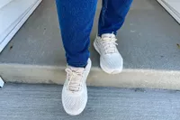 A person wears the Brooks Women's Ariel GTS 23 Running Shoes while walking outside