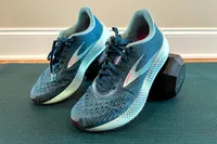 Pair of Brooks running shoes placed on a dumbbell and exercise mat