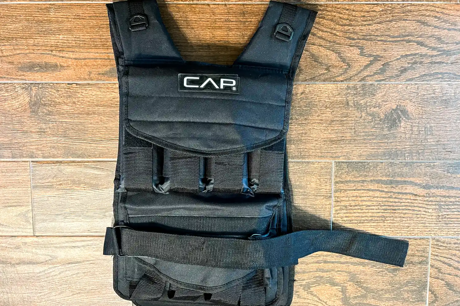 The CAP Barbell 20-150 Lb Adjustable Weighted Vest on a wooden floor