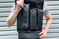 A person removes a weight from the front of the CAP Barbell 20-150 Lb Adjustable Weighted Vest