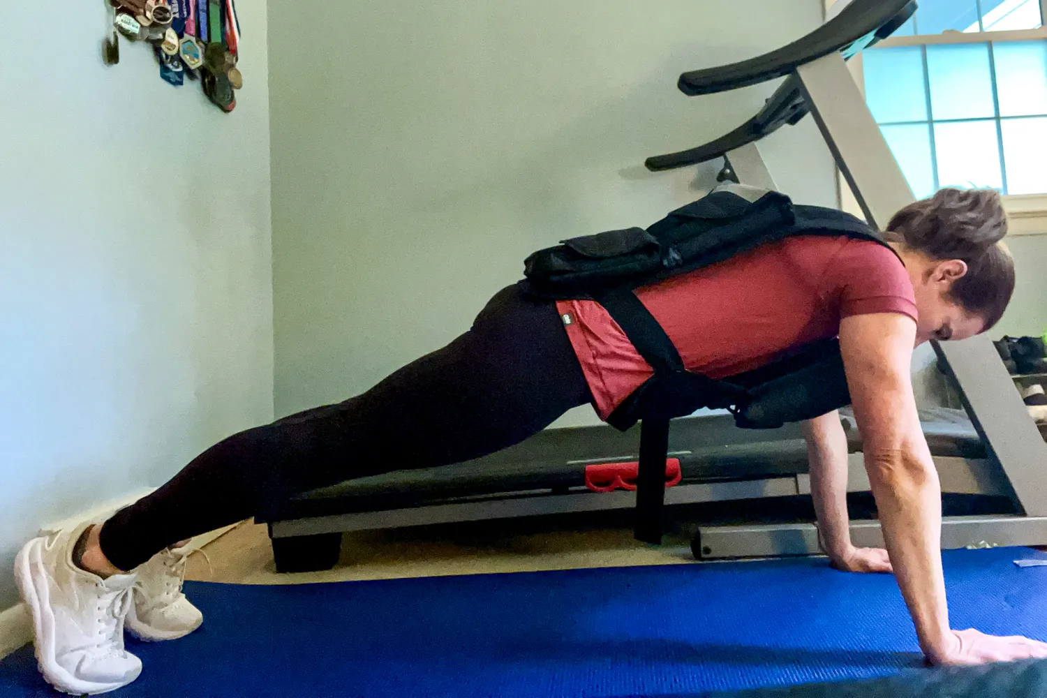 A person does pushups while wearing the CAP Barbell 20-150 Lb Adjustable Weighted Vest