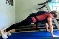 A person does pushups while wearing the CAP Barbell 20-150 Lb Adjustable Weighted Vest