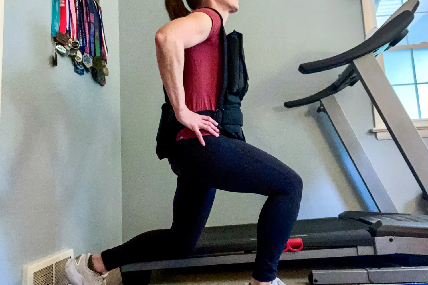 A person does lunges while wearing the CAP Barbell 20-150 Lb Adjustable Weighted Vest