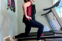 A person does lunges while wearing the CAP Barbell 20-150 Lb Adjustable Weighted Vest