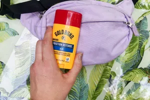 A person holds the Gold Bond Friction Defense Moisturizing Stick