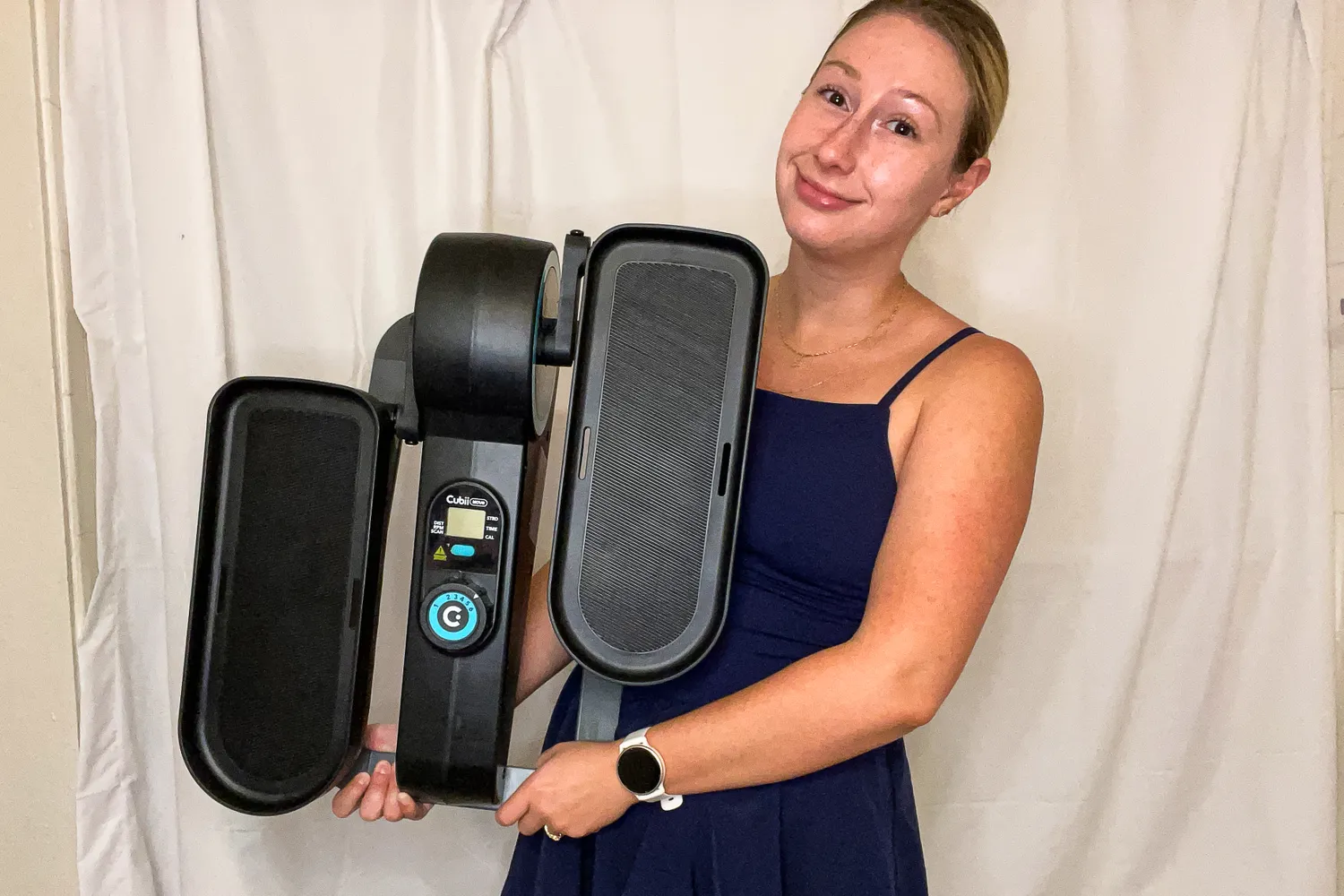 A person lifts the Cubii Move Under Desk Elliptical Bike