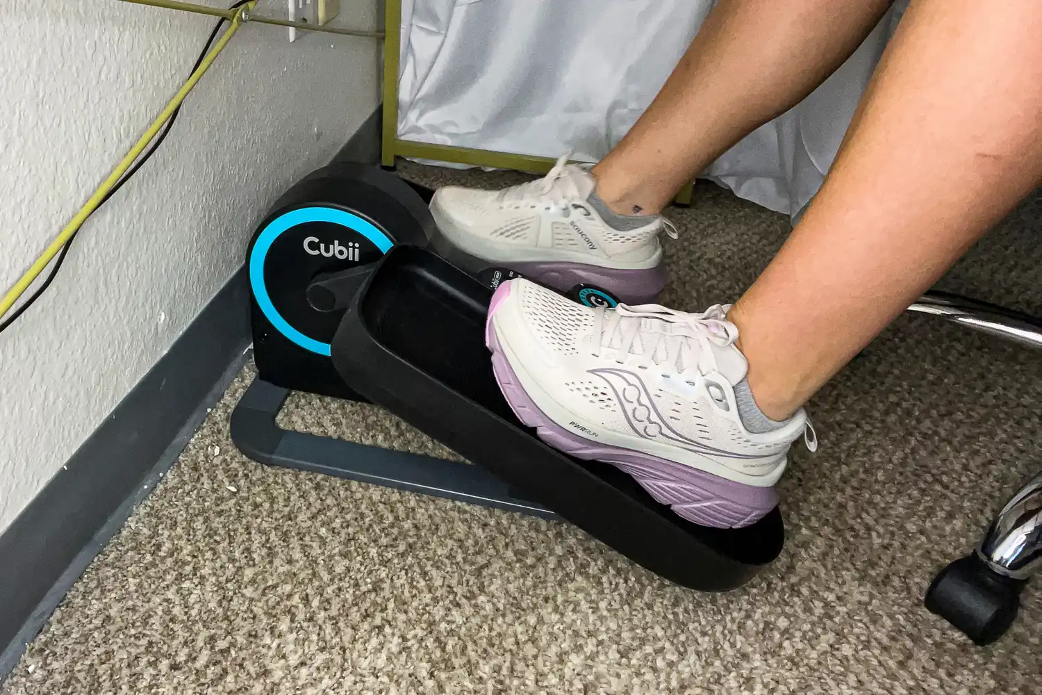 A person exercises with the Cubii Move Under Desk Elliptical Bike
