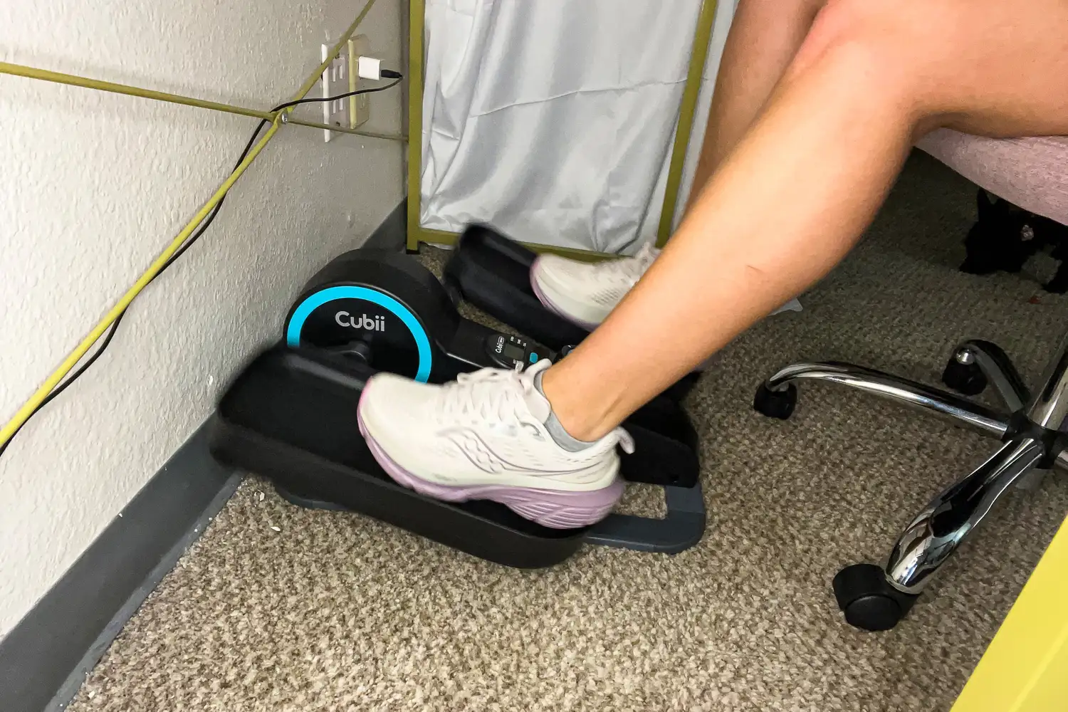 A person pedals the Cubii Move Under Desk Elliptical Bike