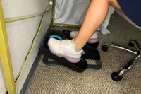 A person pedals the Cubii Move Under Desk Elliptical Bike