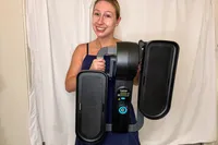 A person holds up the Cubii Move Under Desk Elliptical Bike