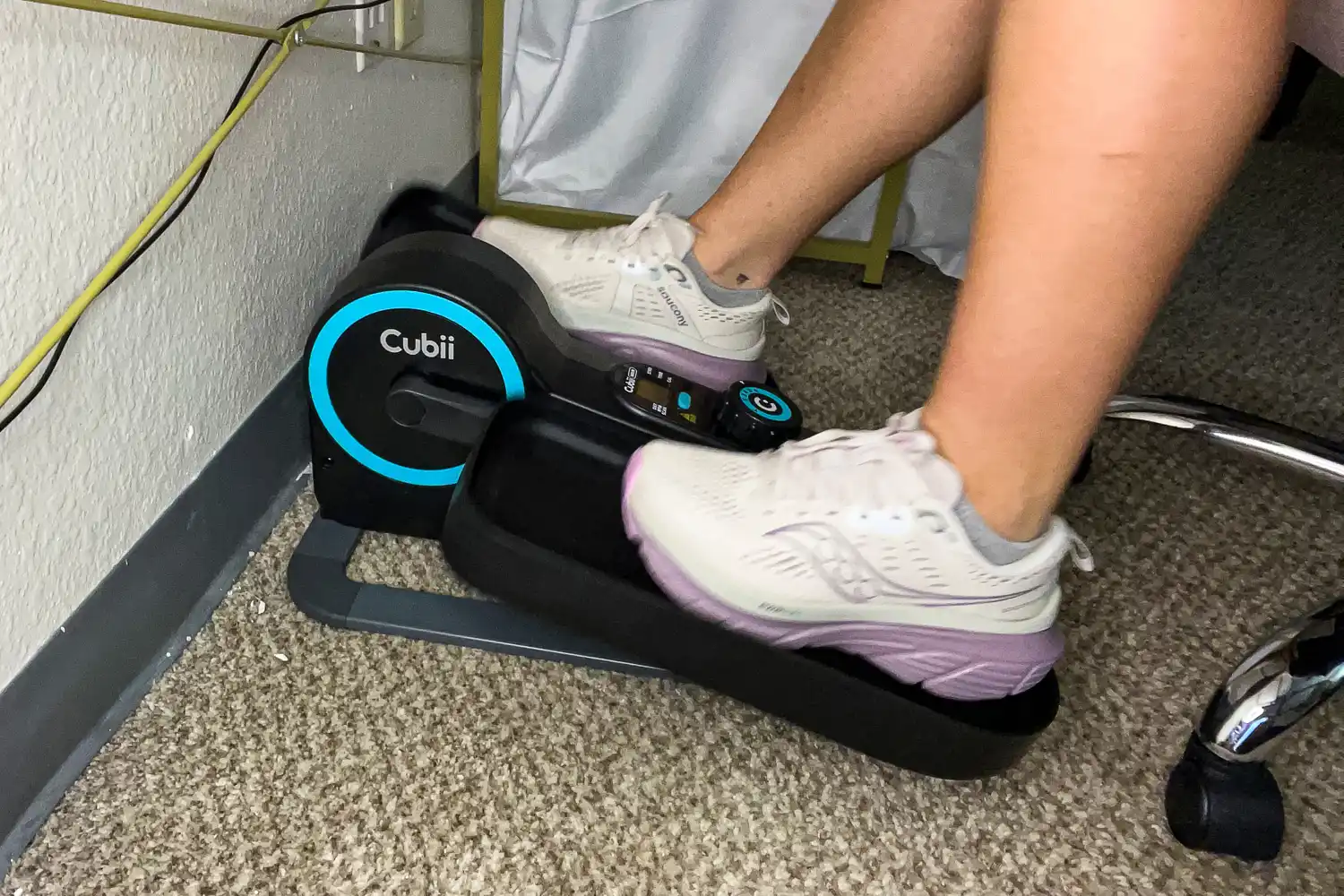 A person pedals the Cubii Move Under Desk Elliptical Bike