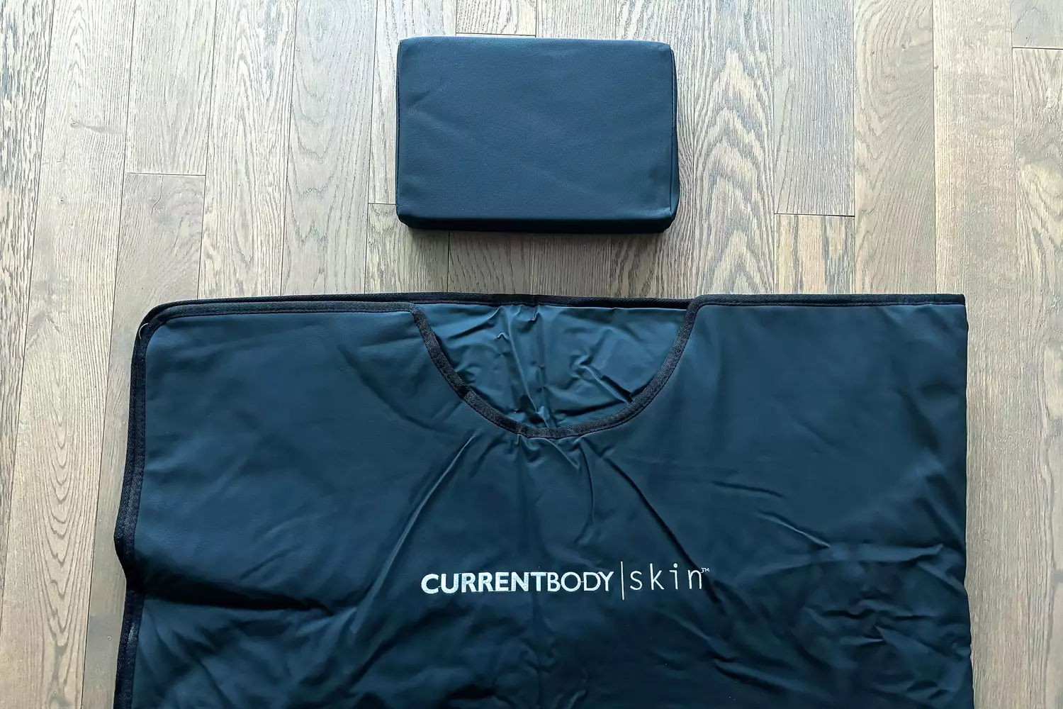 A close-up of the CurrentBody Skin Infrared Sauna Blanket on a wooden floor