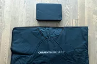 A close-up of the CurrentBody Skin Infrared Sauna Blanket on a wooden floor