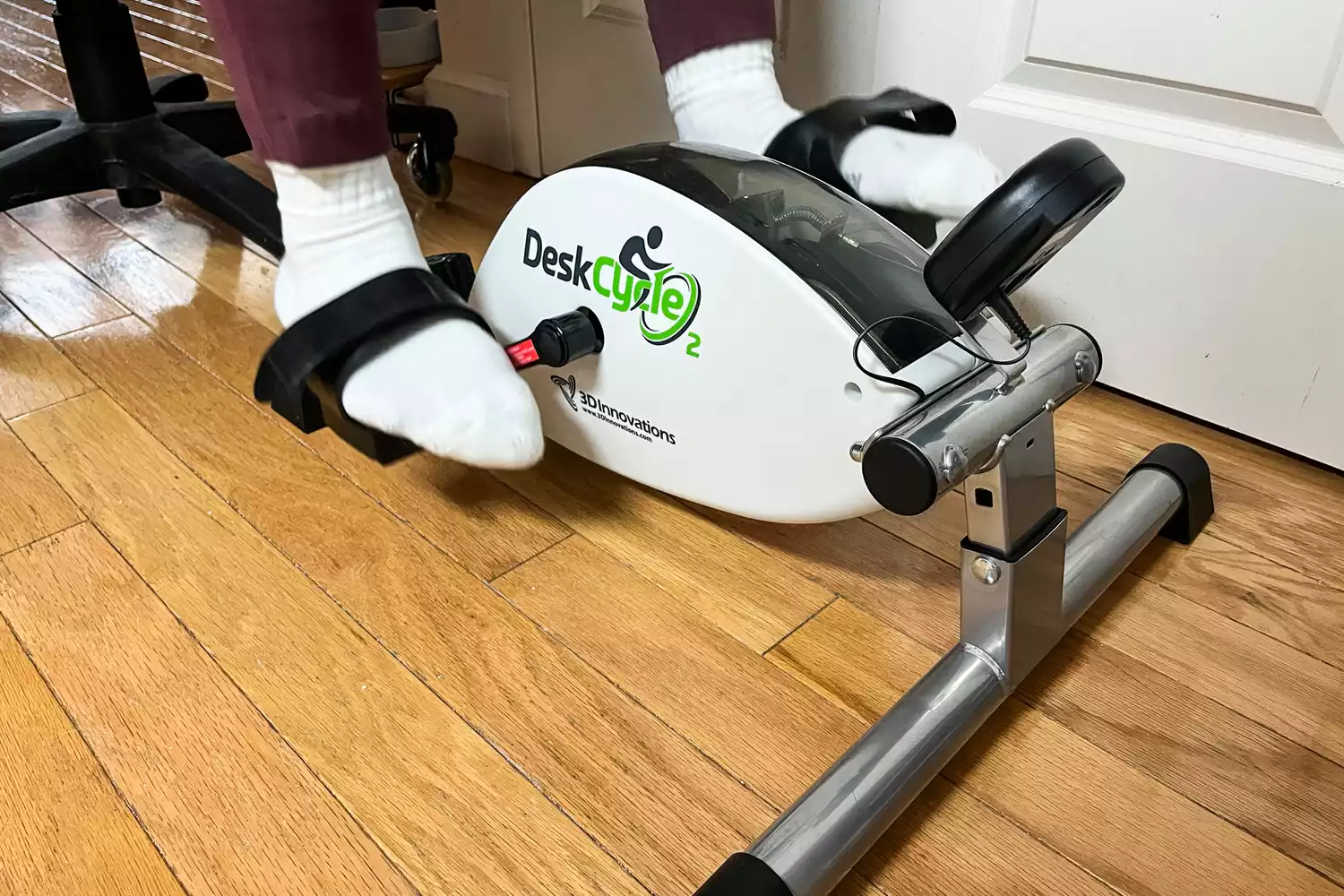 A person uses the DeskCycle 2 Under Desk Bike Pedal Exerciser