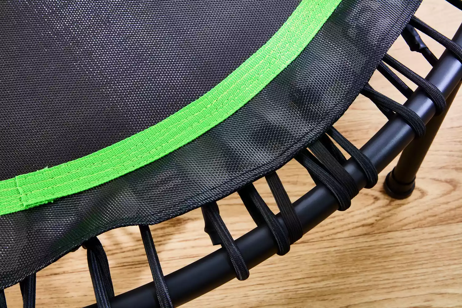 The BCAN 450/550 Lbs Foldable Mini Trampoline strings with a wooden background