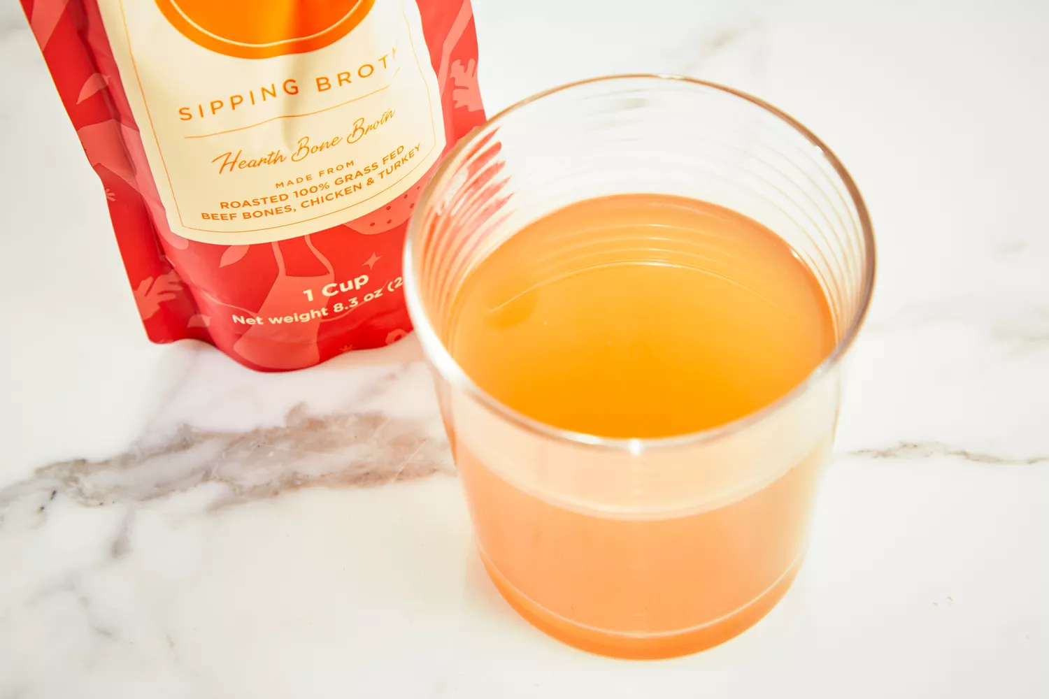 A glass of Brodo Hearth Bone Broth on marble counter