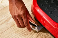 A hand clips a carabiner to the Hurtle Fitness Vibration Platform Machine