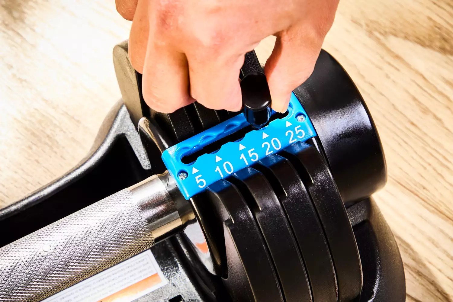 A person adjusts the weight on the Lifepro PowerFlow Plus Adjustable Dumbbell Set